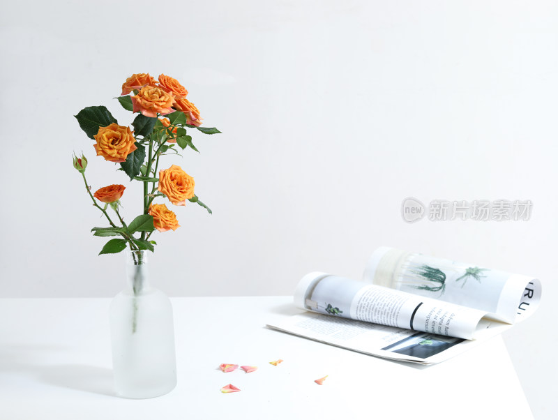 白色桌面上的书籍和一束玫瑰花