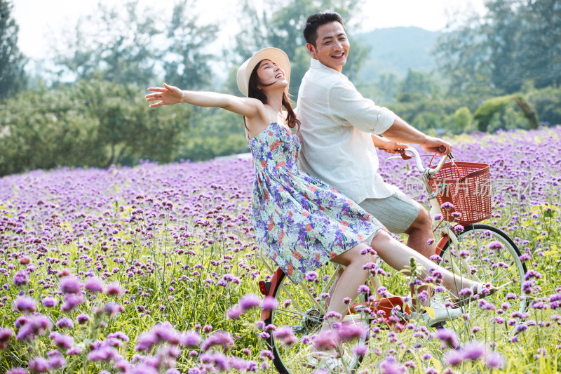 青年夫妇在花海里骑车