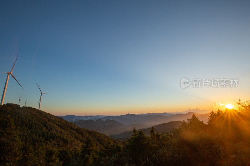 山间风力发电机与日落景象