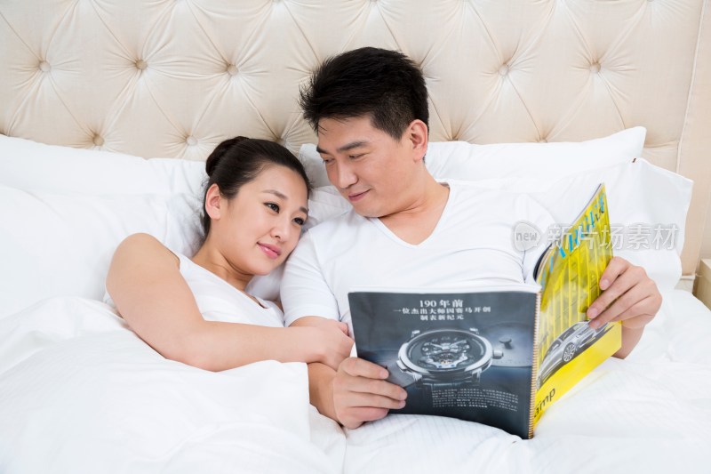 夫妻躺在床上看杂志