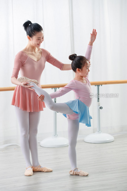 年轻舞蹈老师教小女孩跳舞