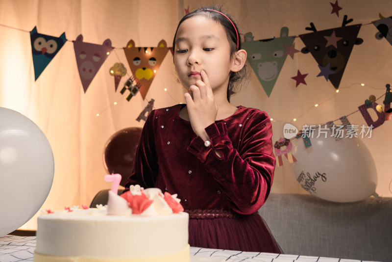 在生日会上吃生日蛋糕的中国女孩