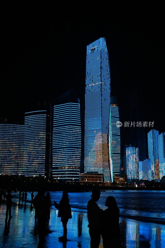 夜晚海滨城市高楼与人群剪影