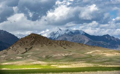 乌云下的雪山与多彩山峦风景