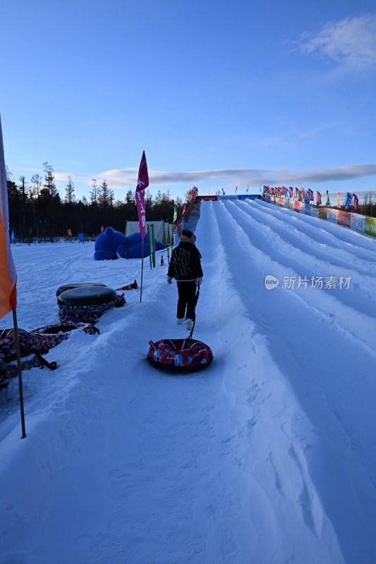 户外滑雪场雪道上有人在玩雪圈