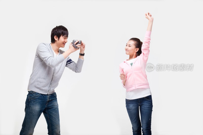 快乐的年轻情侣使用数码摄像机
