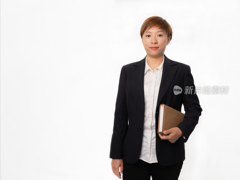 站在白色背景前着职业装拿笔记本的中国女性