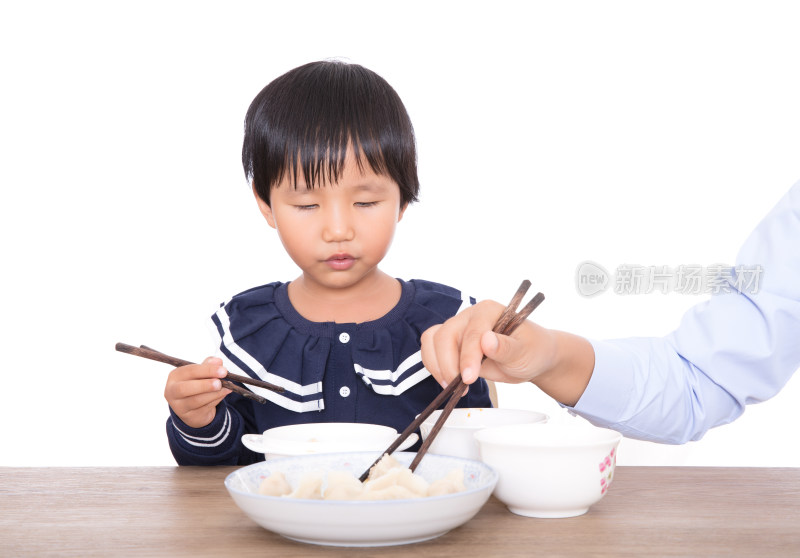 餐桌前妈妈在帮助自己的女儿吃饺子