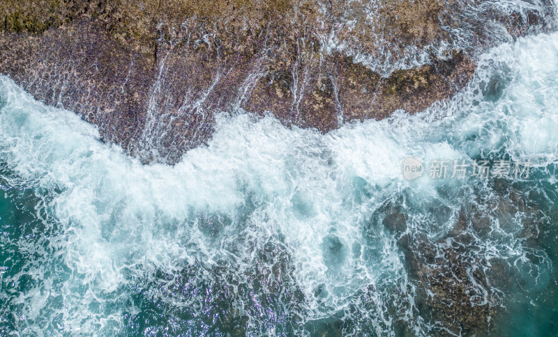 阳光下的海南三亚海岸线上礁石沙滩海浪浪花