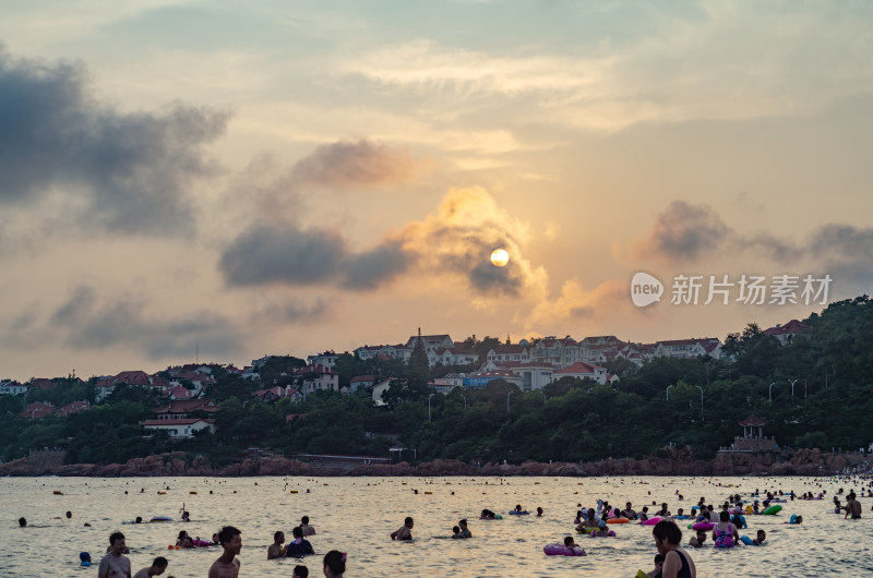 日落时分，青岛海水浴场许多游泳的人