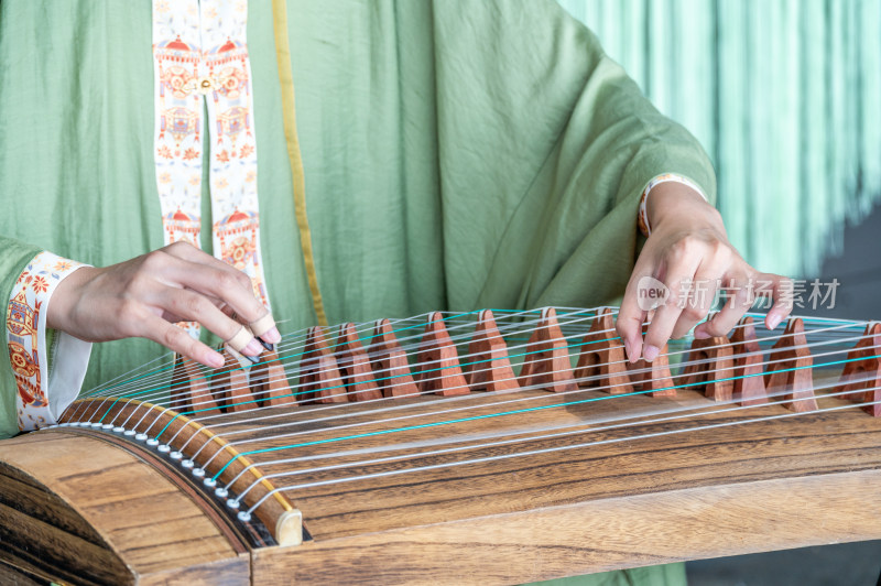 一位身穿中国传统汉服的女子弹奏古筝唯美