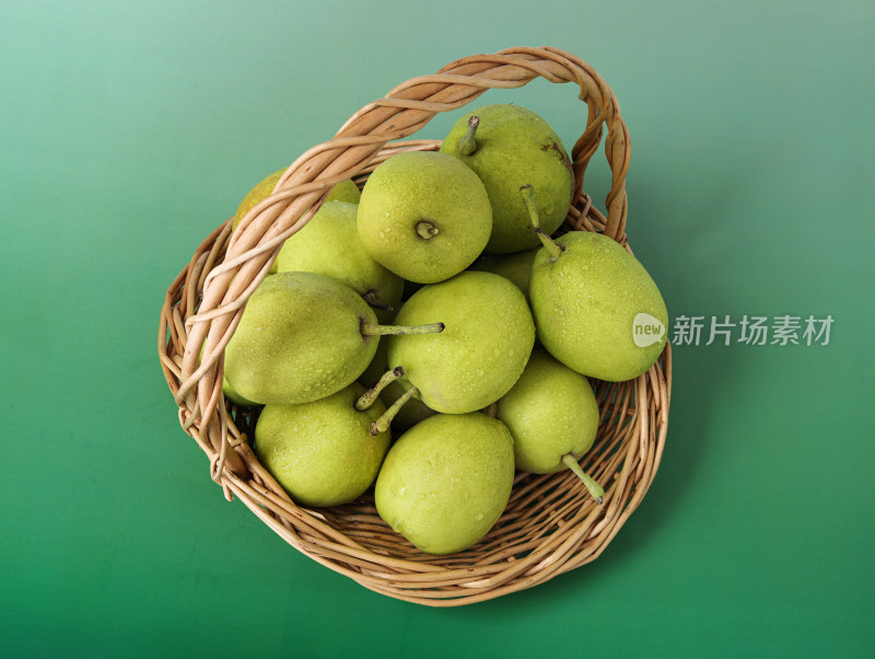 绿色背景上的一篮子新鲜水果香梨