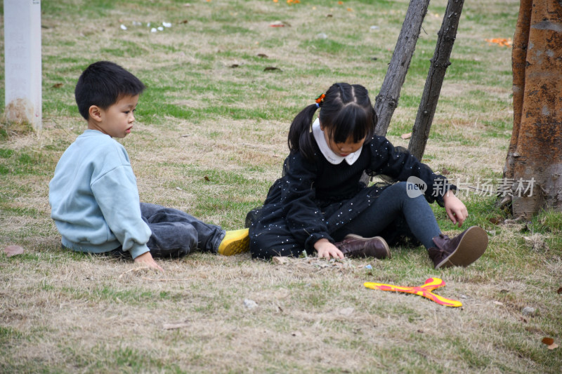 草地中玩耍的小男孩和小女孩