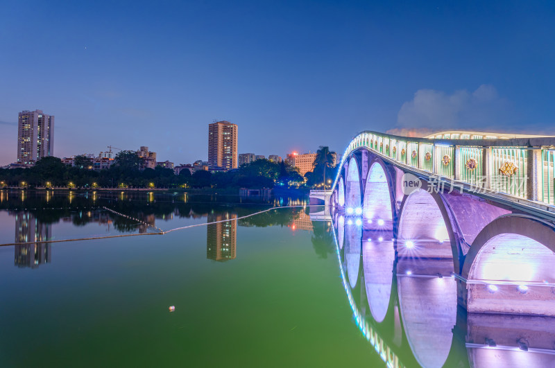 南宁南湖公园石拱桥与城市摩天大楼夜景灯光