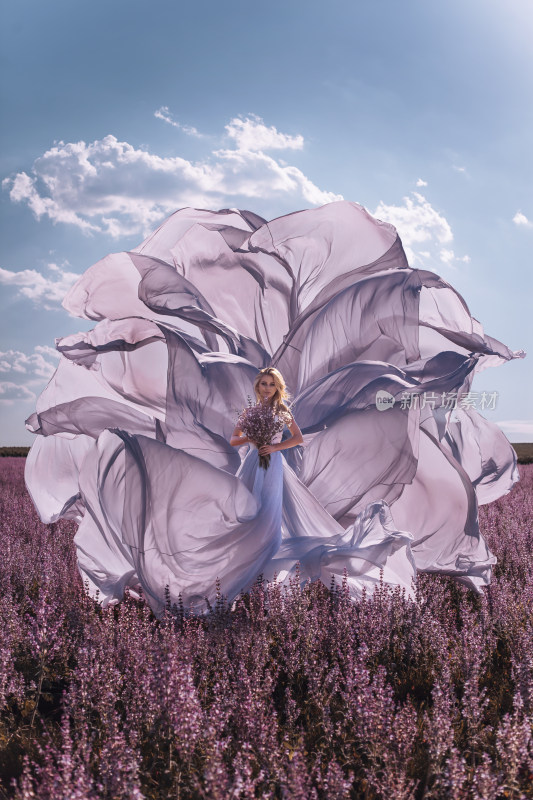 女子于薰衣草田持花纱裙飞扬