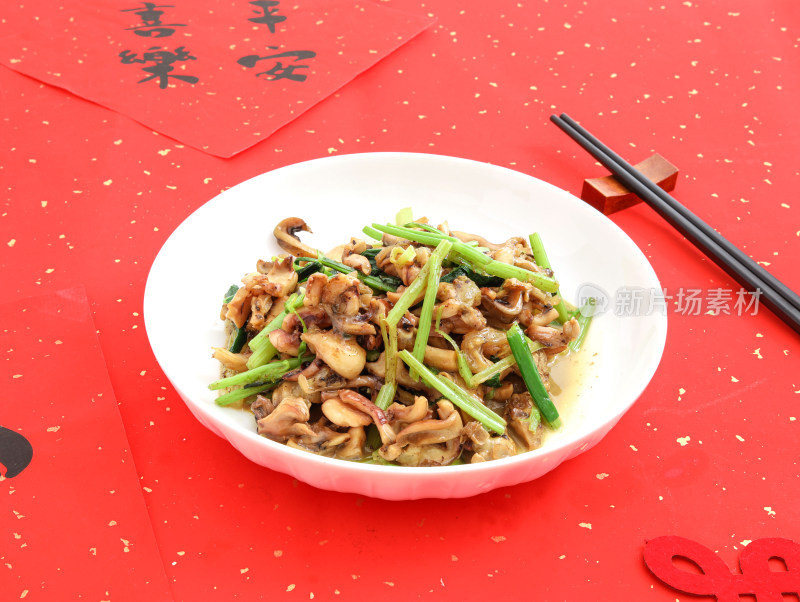 红色背景上的一盘子中餐美食芹菜炒鱿鱼