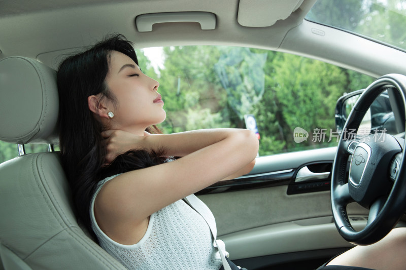 坐在驾驶座上疲劳的青年女人