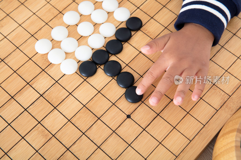 小孩子在棋盘上学习下围棋