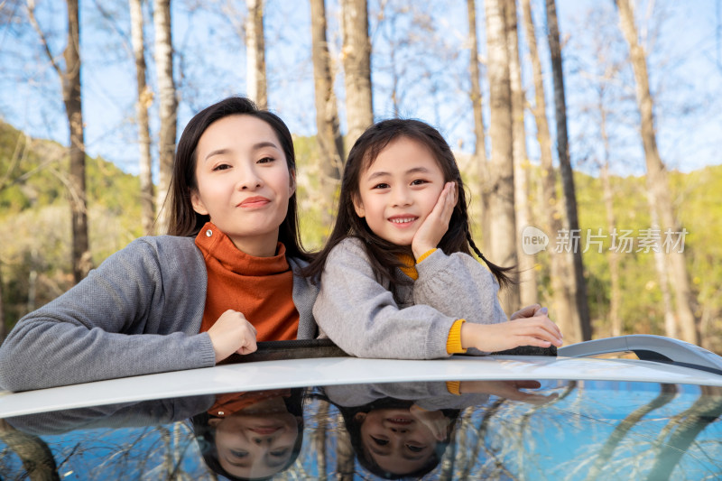 幸福的母女从汽车天窗伸出头来