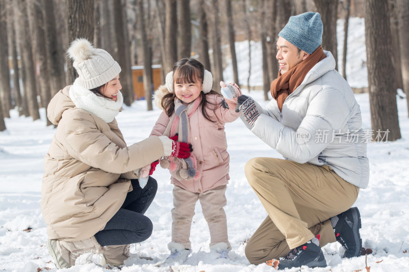 一家三口在雪地里玩耍