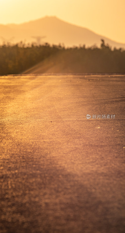 夕阳下的柏油道路与远山