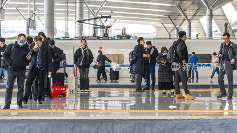 高铁站台上携带行李的旅客