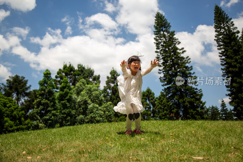 小女孩在草地上欢快跳跃