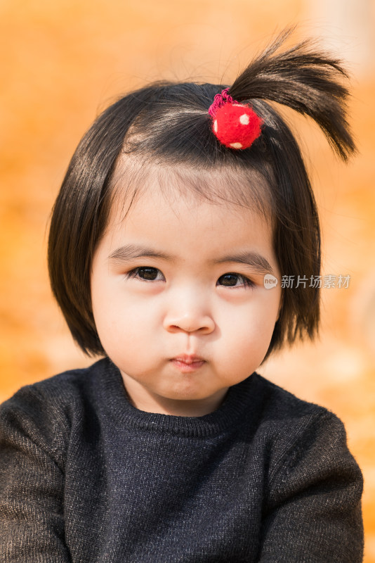 深秋坐在公园落满黄叶的草地上的女孩特写