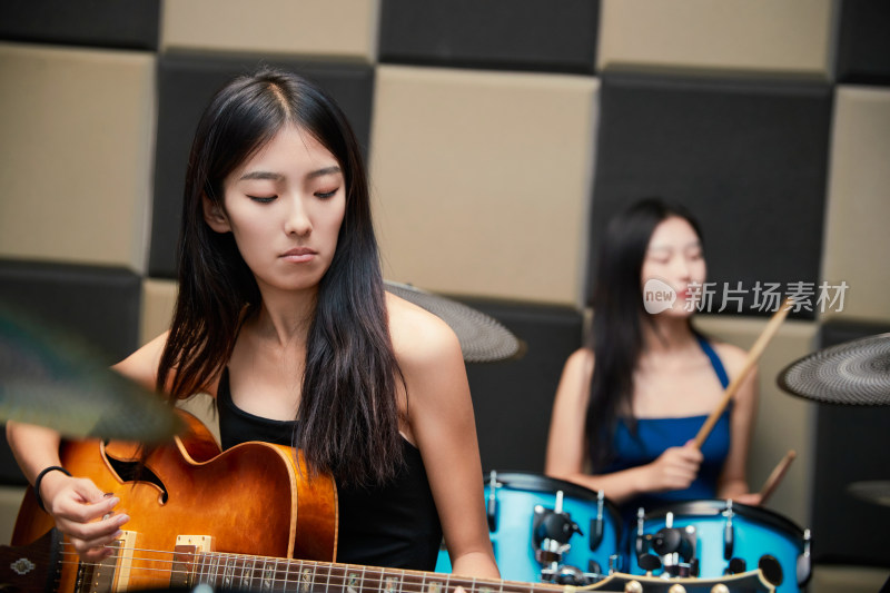 在录音室排练演奏的亚洲少女