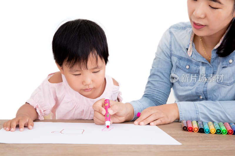 年轻妈妈或幼教老师在教小女孩画画