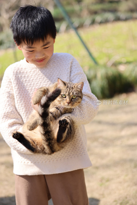 一个中国小男孩和他的宠物猫狸花猫