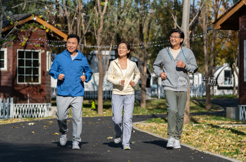 一群中老年人微笑着跑步健身