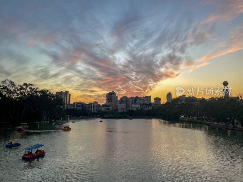 城市湖泊黄昏景色下的游船景象