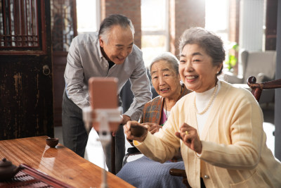 快乐的老年人用手机直播喝茶