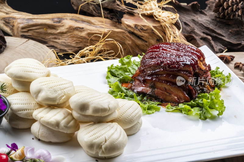 长方形瓷盘装的花馍夹酱肉摆放在樟木砧板上