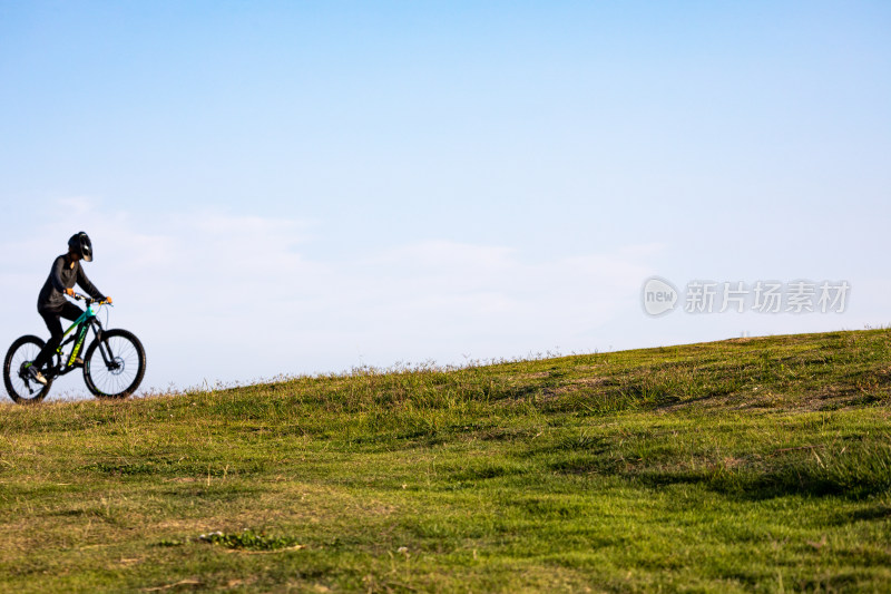 山东青岛海之恋公园海滨草坡上骑单车的少年