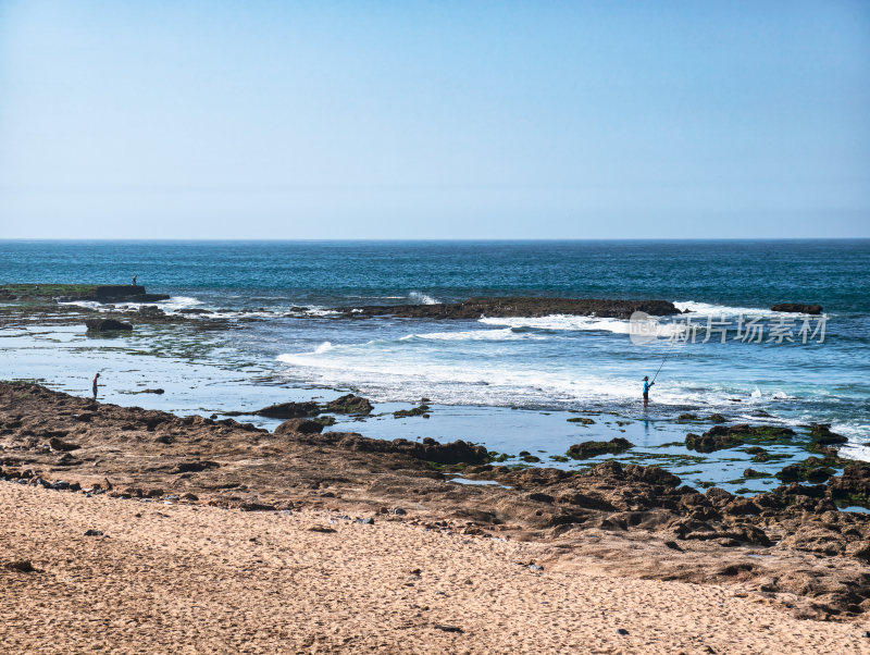 海边礁石处的垂钓者