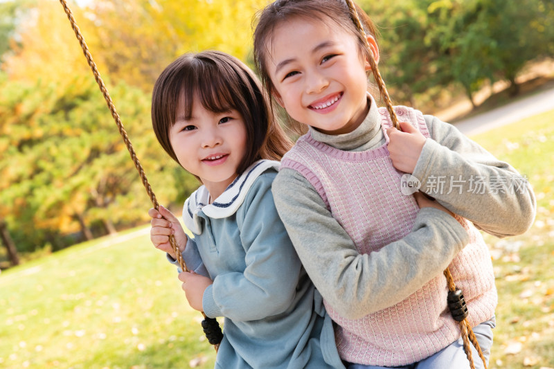 两个女孩在公园里荡秋千