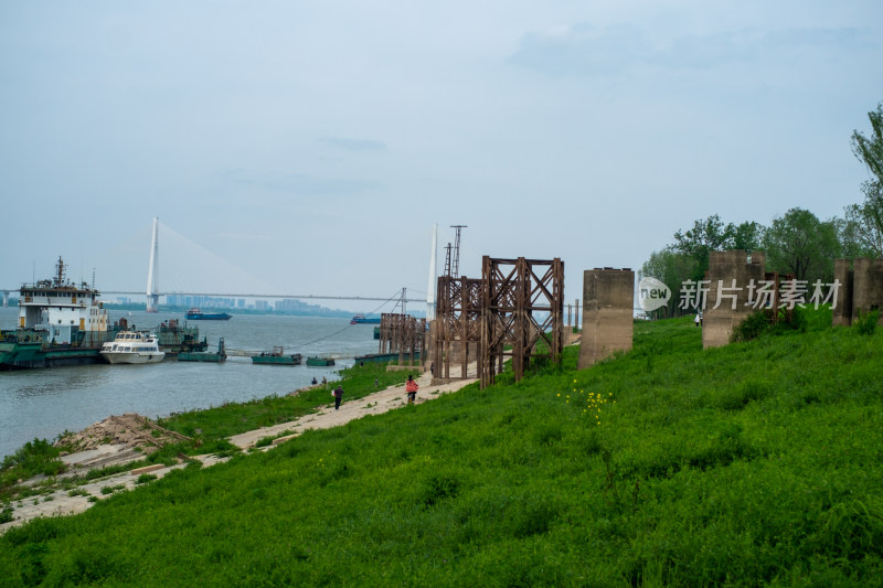 江边草地旁的旧建筑与江面上的船只