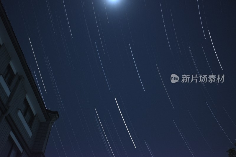 夜空下建筑旁的星轨景象