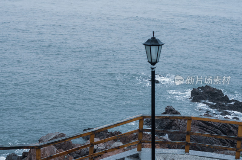 青岛小麦岛，海边的栏杆旁有一盏台灯