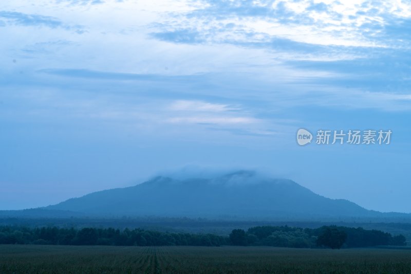 晨雾笼罩的田野与远山景观