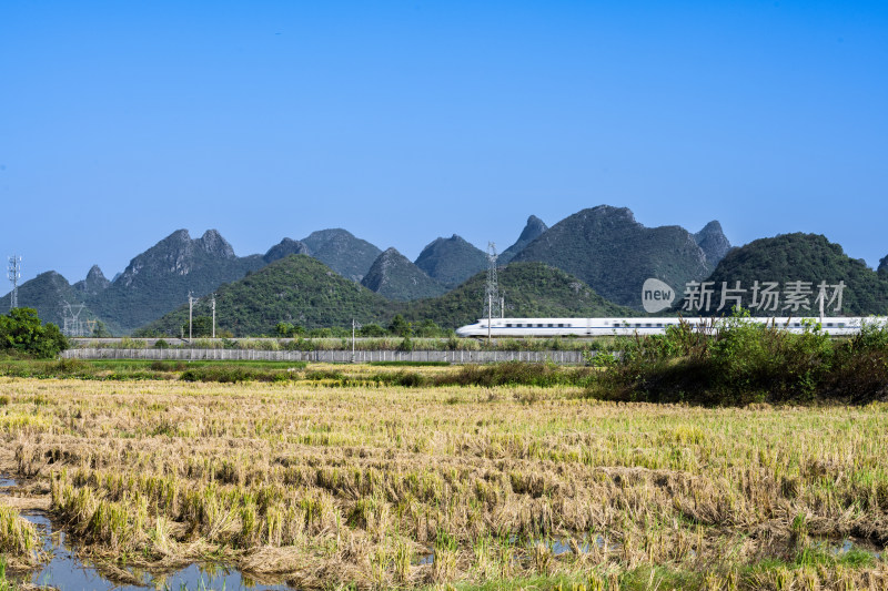 万里无云天空下桂林山边铁路上的高速列车