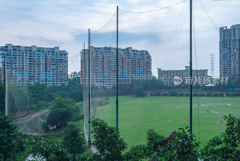 城市高楼住宅建筑与高尔夫练习场绿色草坪