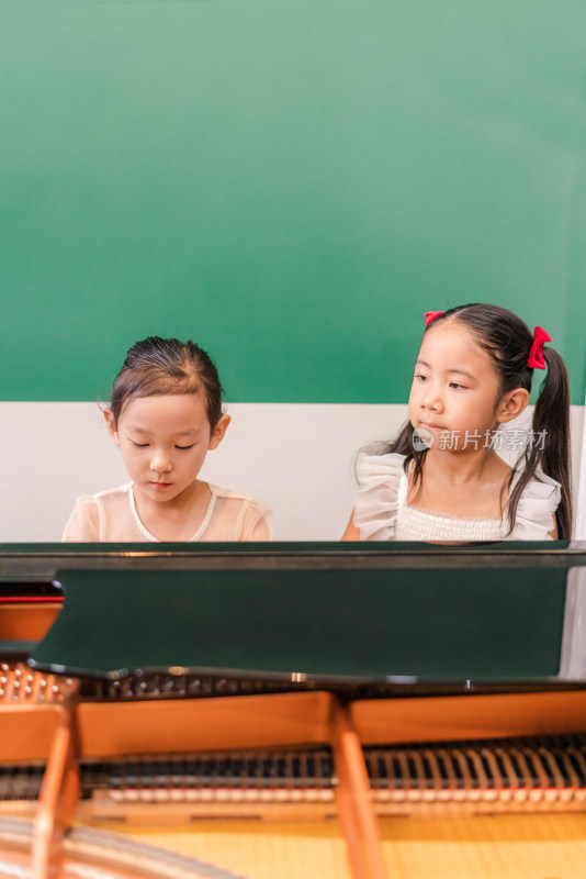 两个正在弹奏钢琴的中国女孩