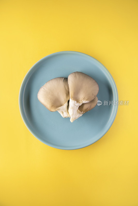 黄色背景中蓝色盘子里的蘑菇片
