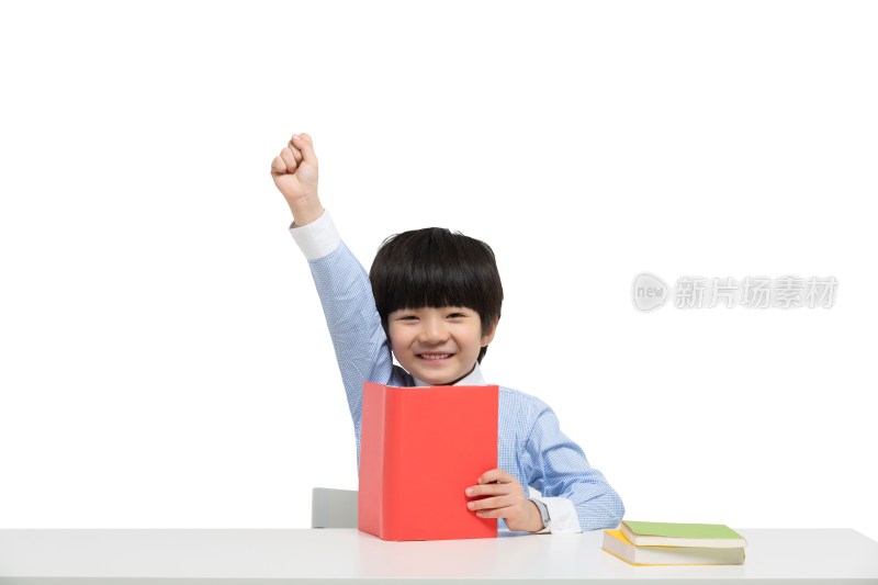 小男孩坐在书桌前拿着书本