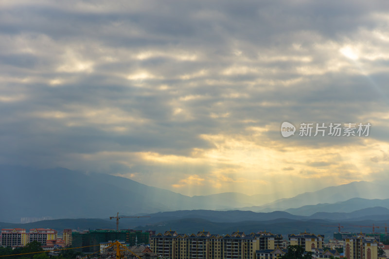 云隙光下的城市山峦