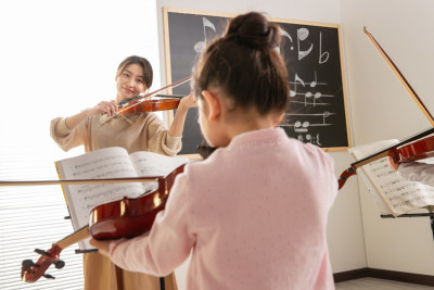 青年女人教儿童上音乐课