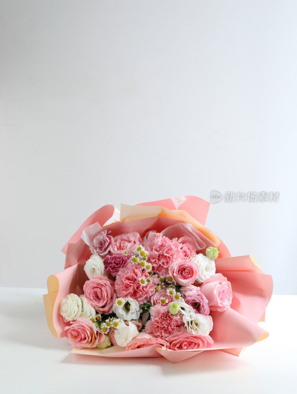 白色桌面上一束粉色的鲜花